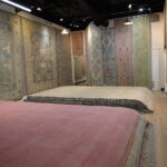 Turkish Oushak rug gallery in Dallas featuring handwoven pastel rugs in pink, blue, and beige tones displayed in a luxury showroom by RugGuys TX.